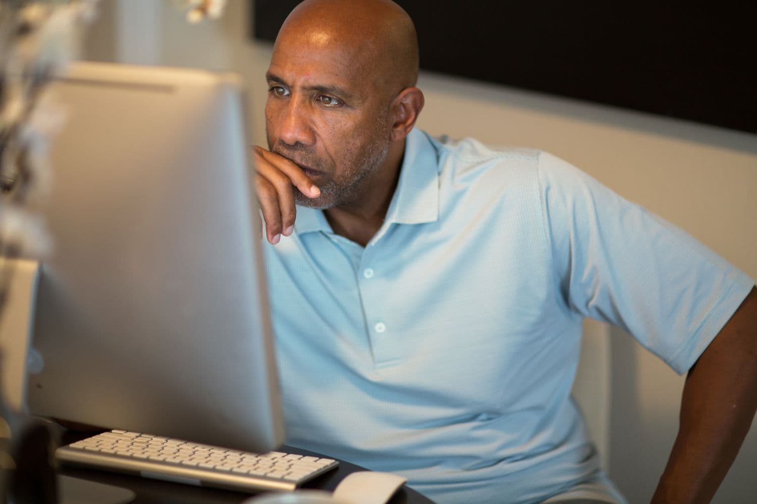 Person Looking at Computer - Roth IRA Benefits and Disadvantages